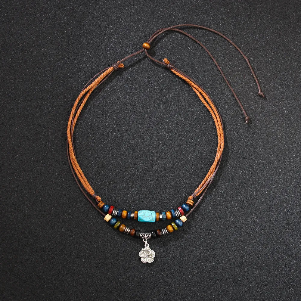 Turquoise wax rope necklace with geometric alloy pendant featuring floral engraving details