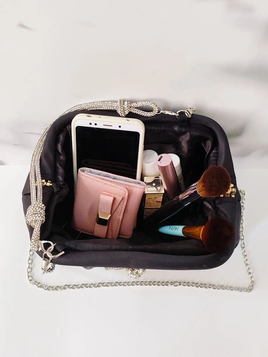 Women's black shoulder messenger bag with document compartment, soft polyester material, and chain decorative details