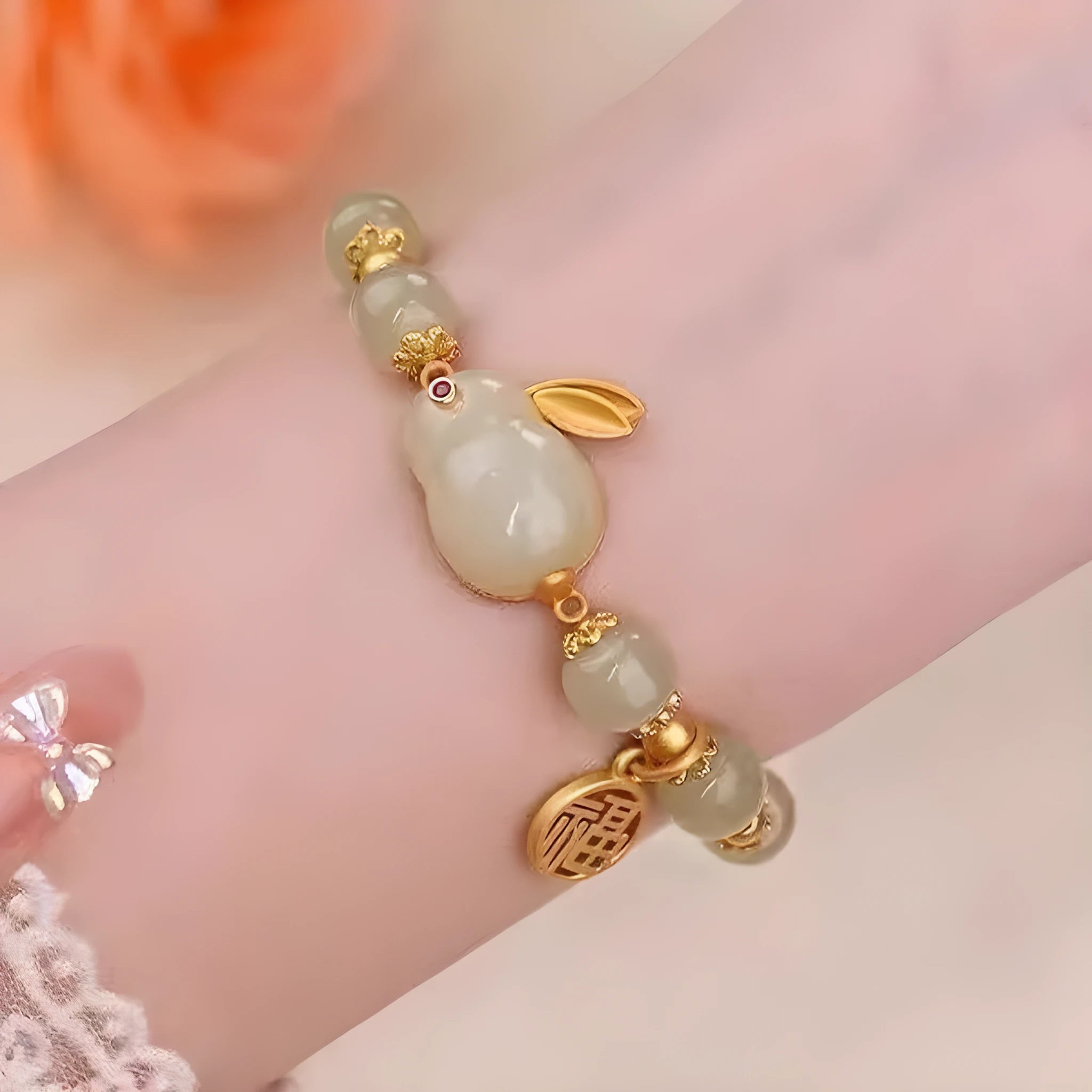 Green jade hare bracelet with black cord showing fu character charm and lily detailing
