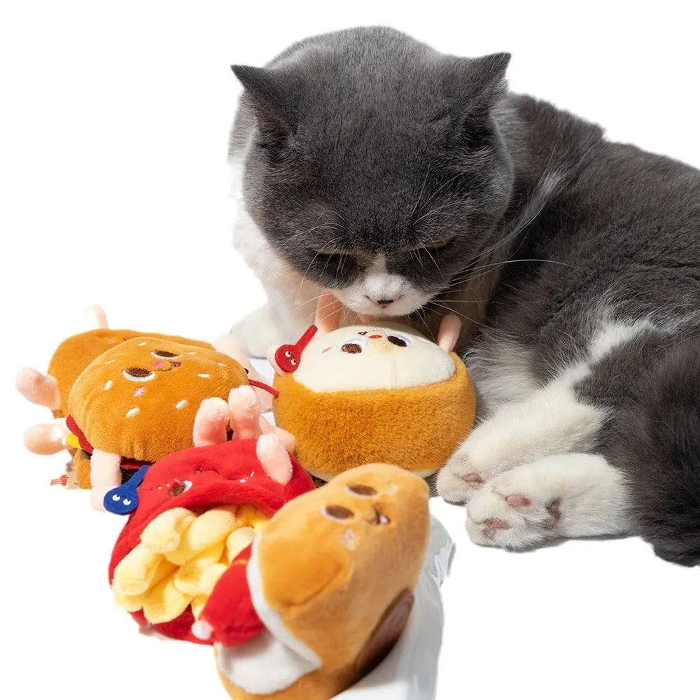 Set of five colourful cat chewing toys shaped like hamburger, chicken legs, fries, hot dog, and bread slice on a white background.