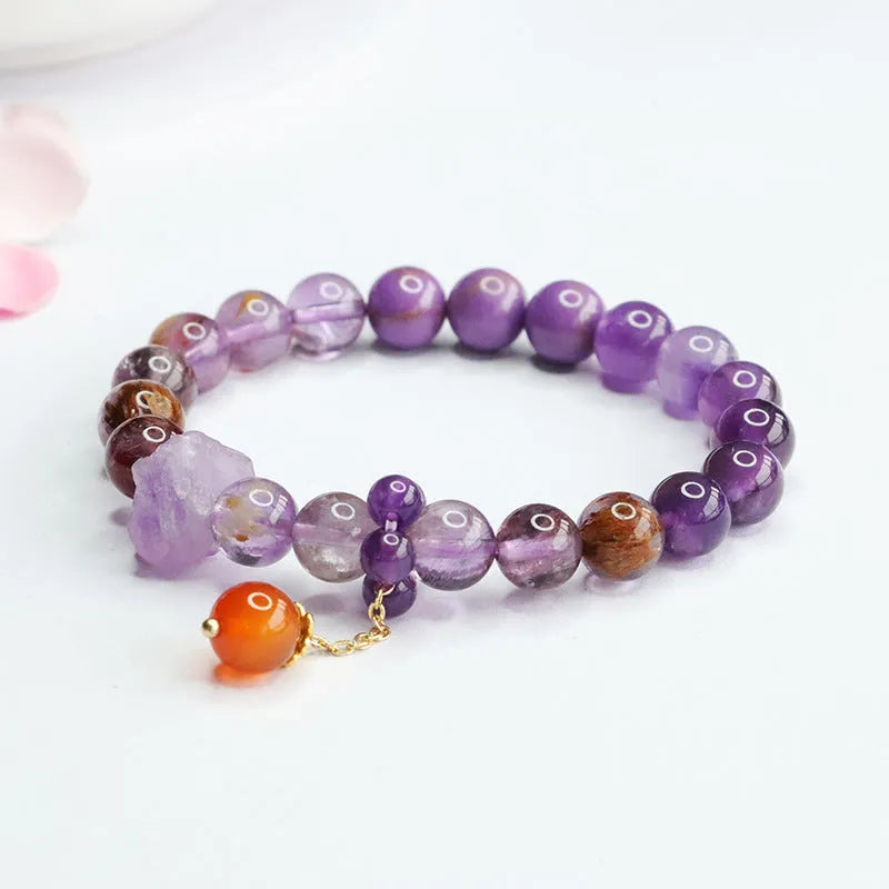 Adjustable nine purple amethyst and red agate Mori-style crystal bracelet showing 8mm beads and organic stone arrangement