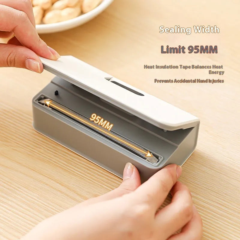 Small white portable heat sealing machine for plastic food bags on a kitchen counter.