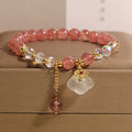 Women's strawberry quartz and white agate crystal bracelet with auspicious clouds charm.