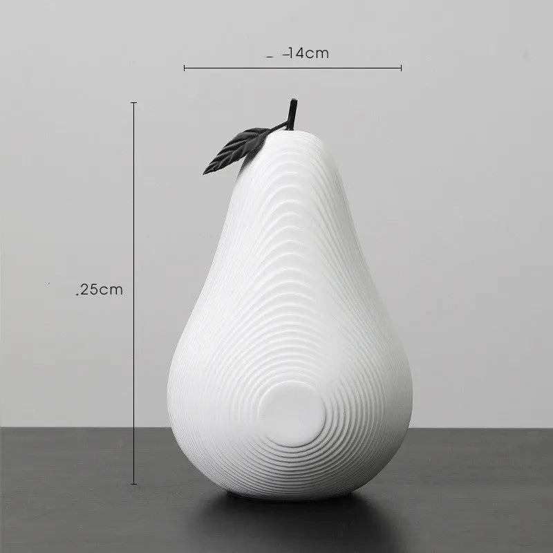 Simple resin apple and pear decoration in white, black, orange, or blue on a table.
