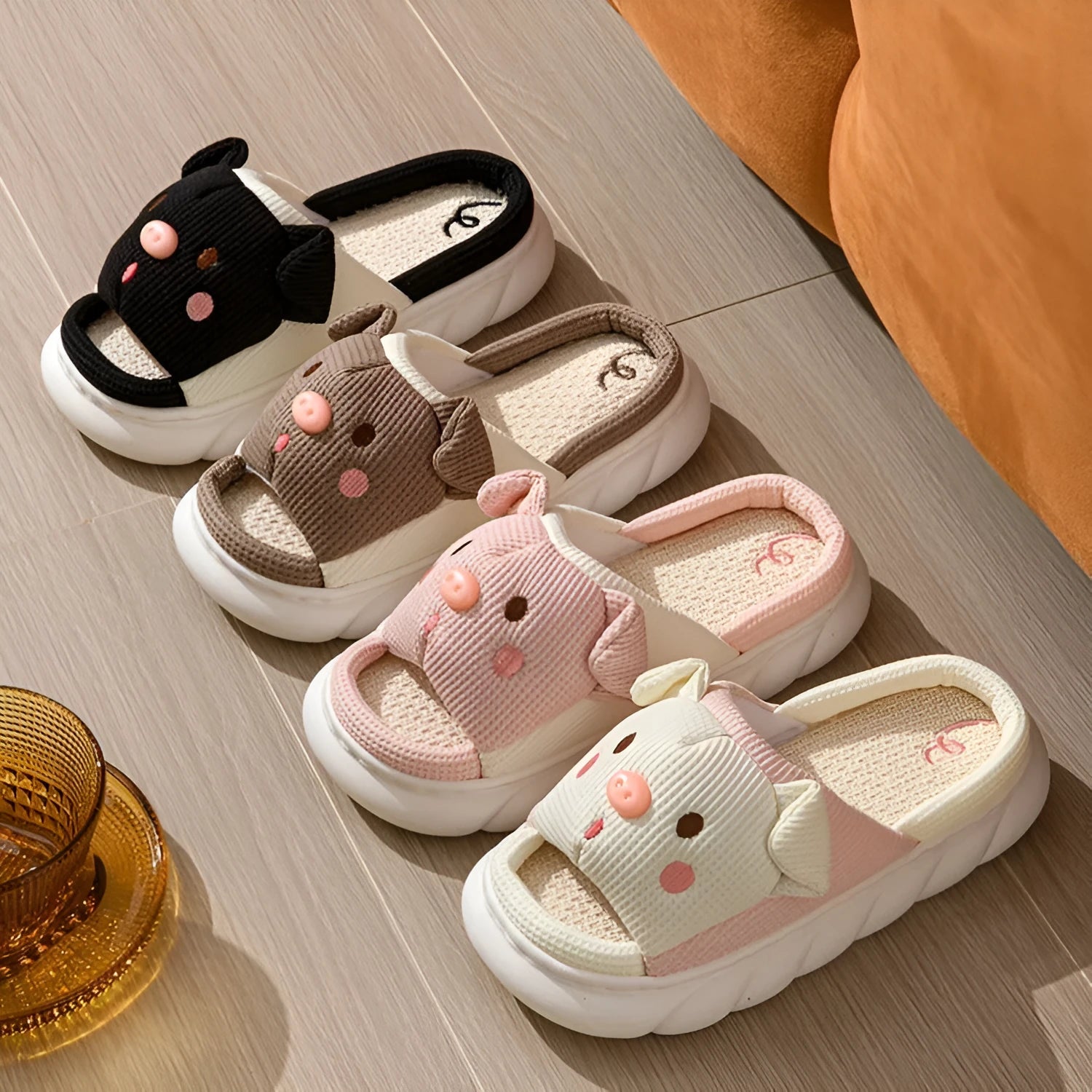 Pair of piggy cute open toe linen flip flop slippers for couples on a plain background.