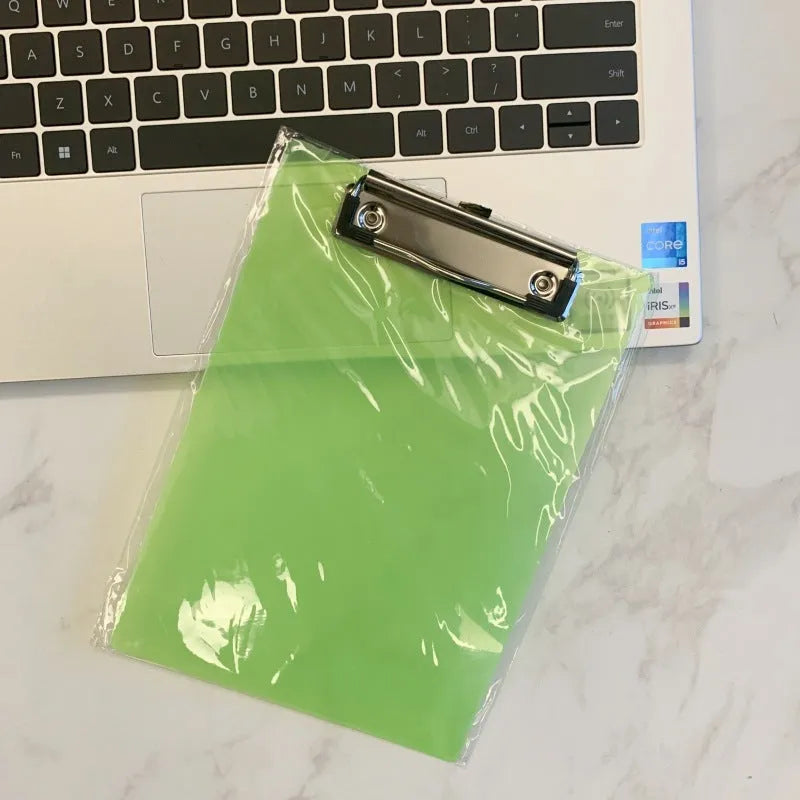 Clear A4 plate holder with metal clip and transparent writing pad in blue colour on a desk.