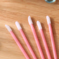 Pack of multi-coloured disposable lip brush applicators with flocked tips on a white background