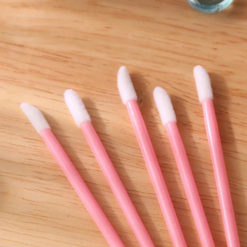 Pack of multi-coloured disposable lip brush applicators with flocked tips on a white background