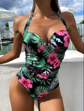 Printed halter neck one-piece swimsuit with a backless design on a mannequin.