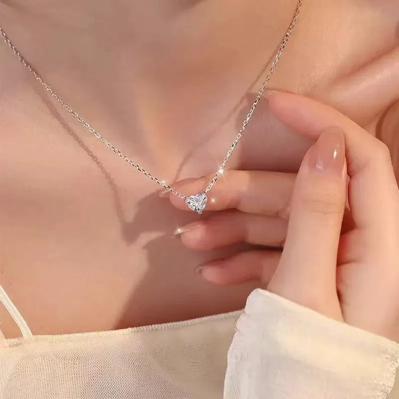 Simple silver-coloured women's necklace with a small love heart pendant on a chain.