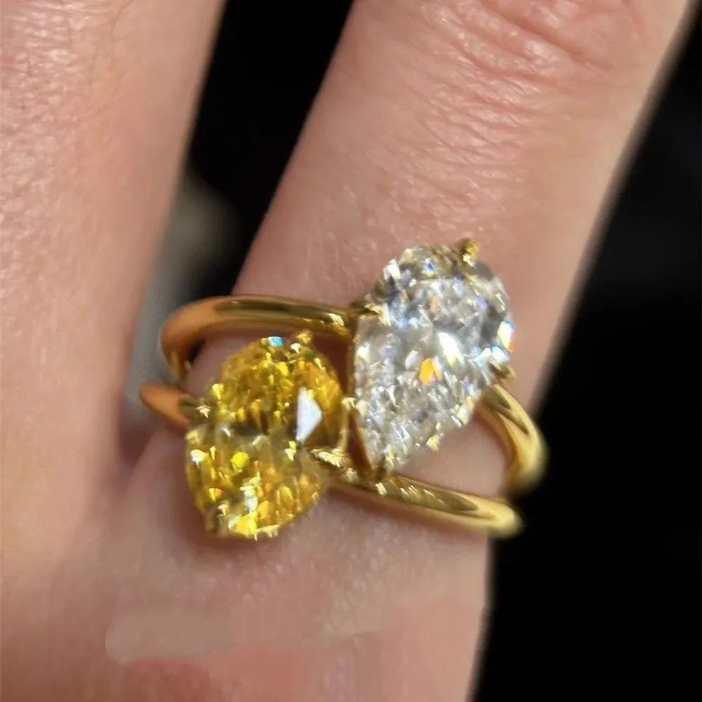 Geometric open copper ring with central water drop double Sheng stone accent on woman's finger