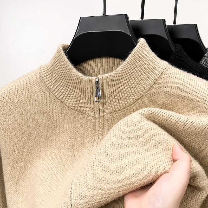 Man wearing a beige high collar knitted cardigan with a full-length front zipper, showing loose fit.