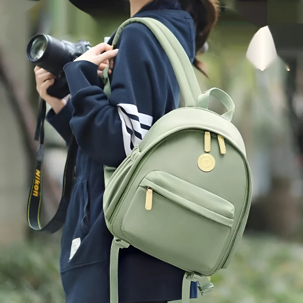 Green polyester shoulder camera bag for women with a curved strap and front patchwork panel.