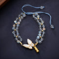 Grey moonstone bracelet with butterfly weave pattern on woven cord