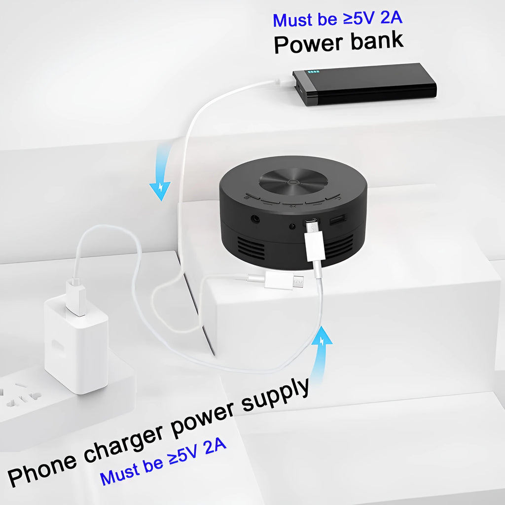 Black portable mini projector for children next to a smartphone for scale