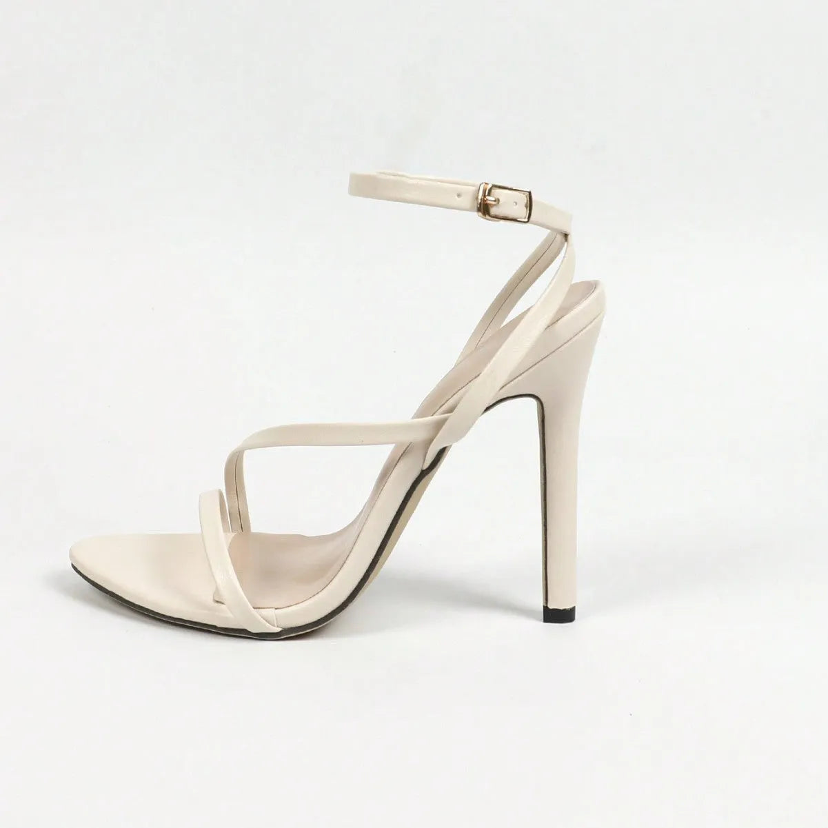 Women's gold multi-stripe cross ankle strap heels with open toe and round toe shape on a neutral background
