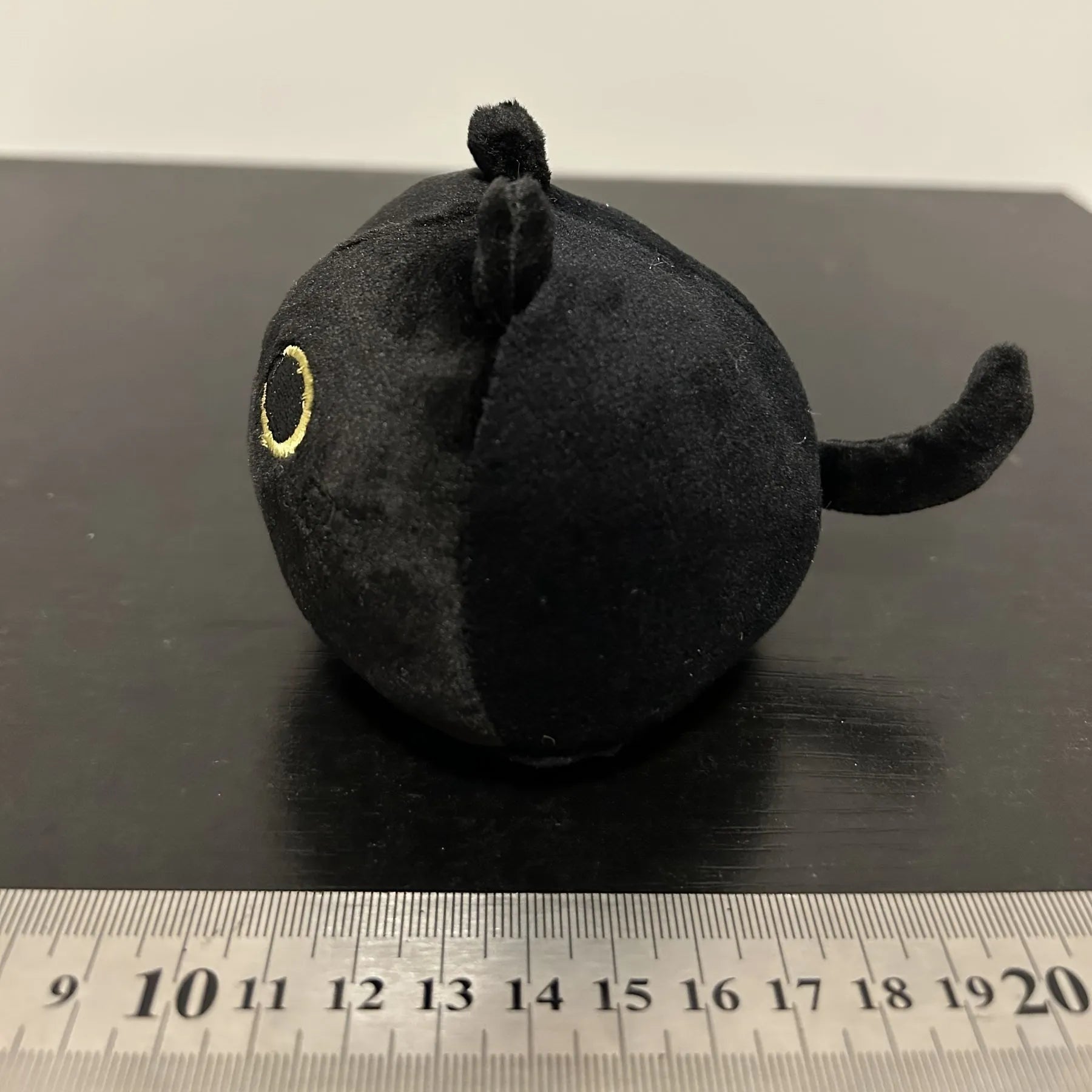 Fluffy black cat plush toy with soft texture, shown as a decorative cushion