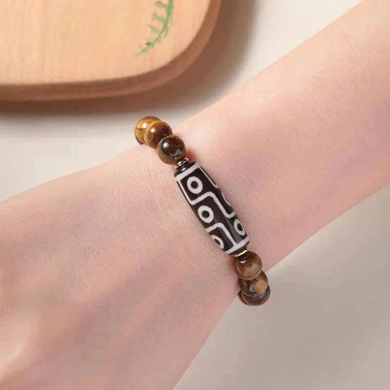 Close-up of a single circle tigereye stone Buddha rosary bracelet showing the chatoyant beads on a string.