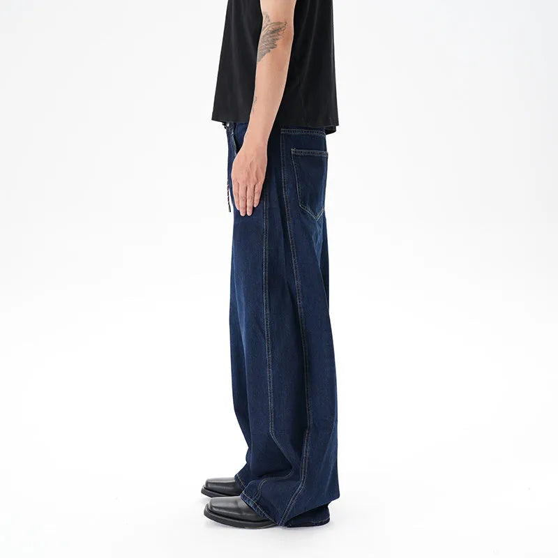 Dark blue wide leg jeans with a distressed wash and machete cut, laid flat.