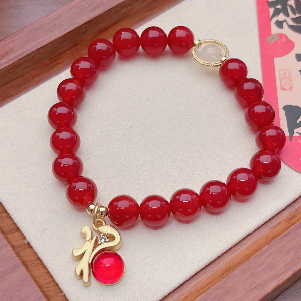 Women's handcrafted red agate bracelet with Chinese dragon design and lucky charm elements