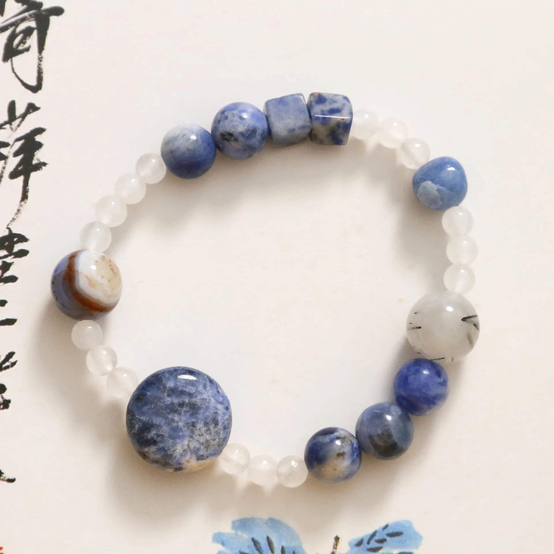 Hand-woven natural stone bracelet with blue point stone and black hair crystal agate in geometric design