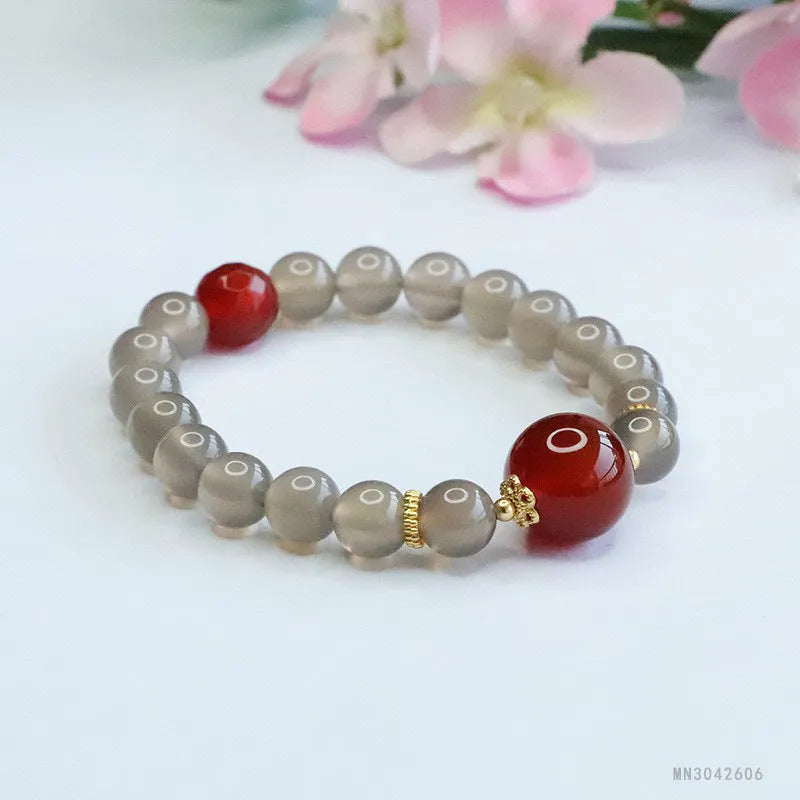 Natural smoky purple and red agate bracelet with 8mm geometric beads on a wrist.