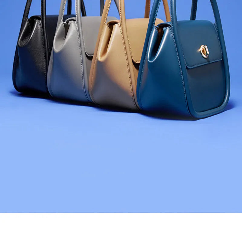 Leather tote cross-body wing bag in soft cow leather with latch closure and wing shape design.