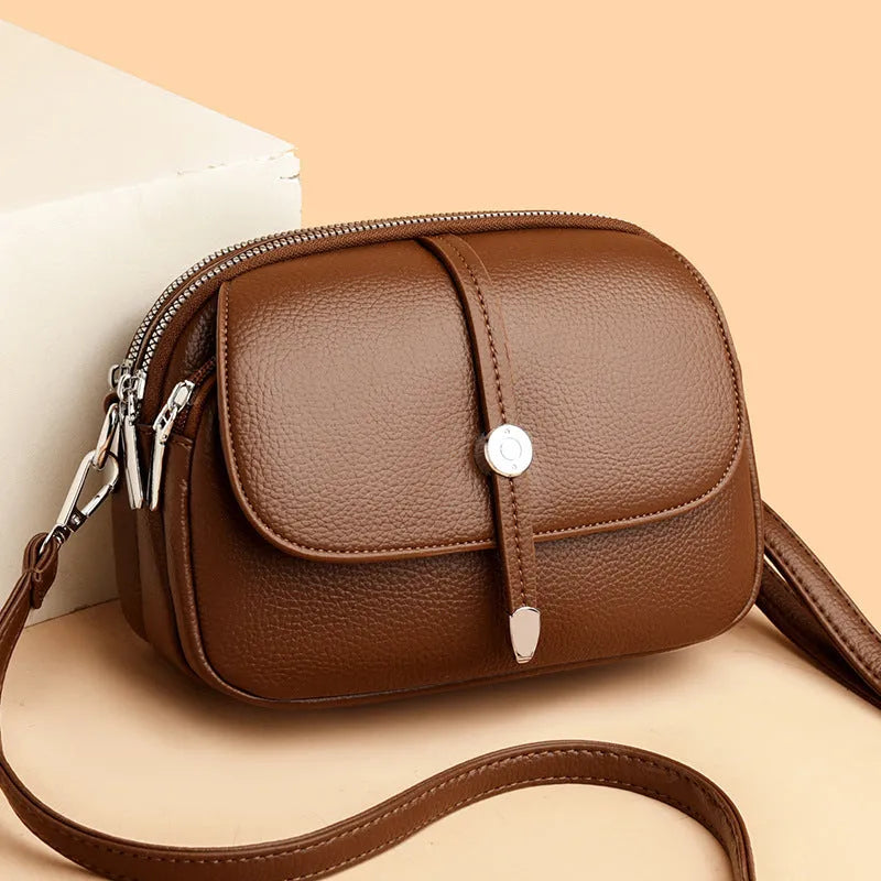Women's soft PU oval crossbody shoulder bag with sewing thread detailing in dark brown