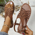 Black Roman style beach slippers with cross straps and flat buckle on open toe design