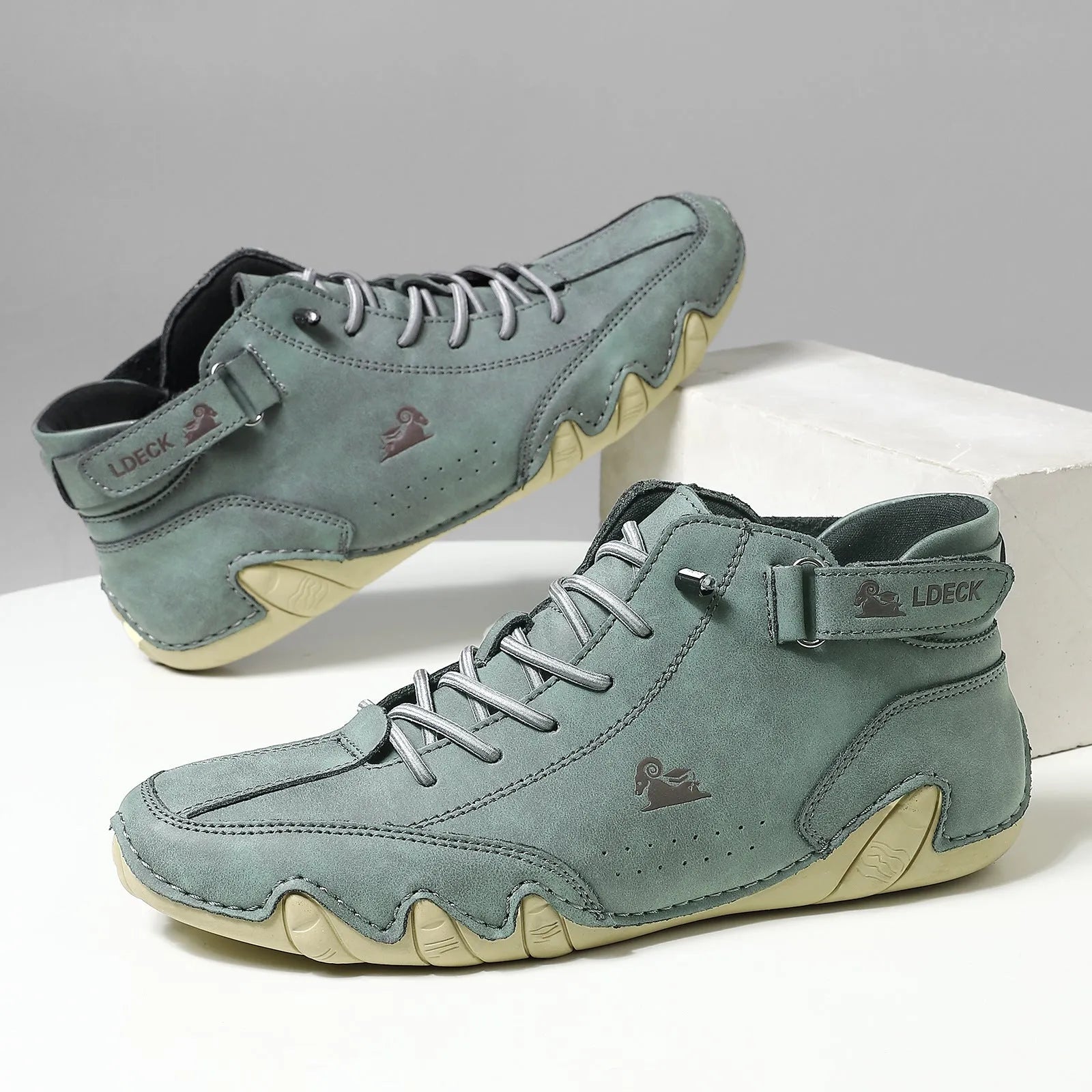High top men's shoes in khaki with rubber soles and microfiber uppers, showing round toe and pigskin boot tube