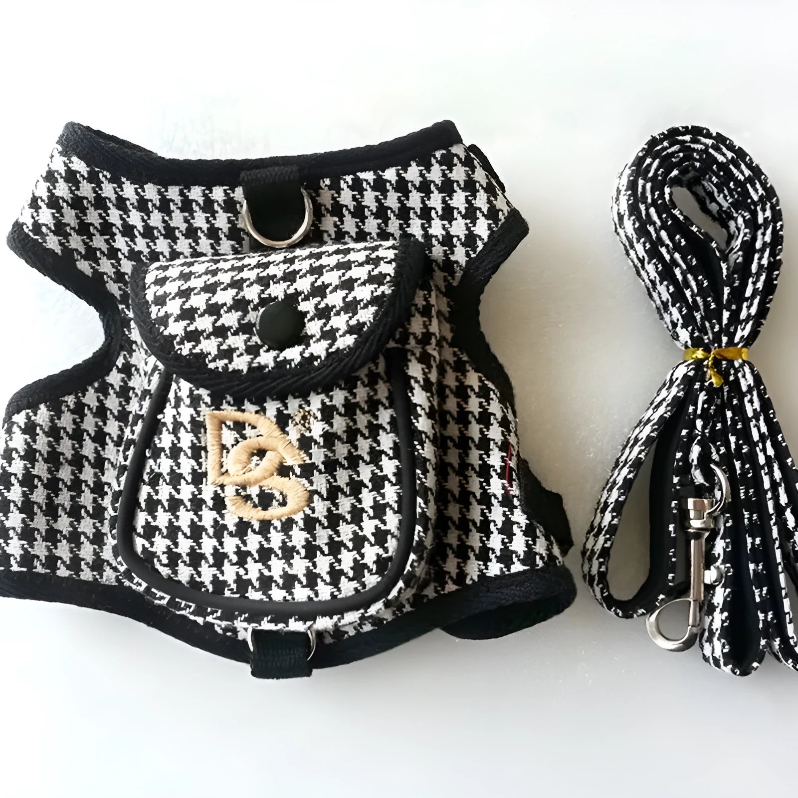 Black houndstooth cotton vest for a small dog, showing the leash attachment strap on the back.