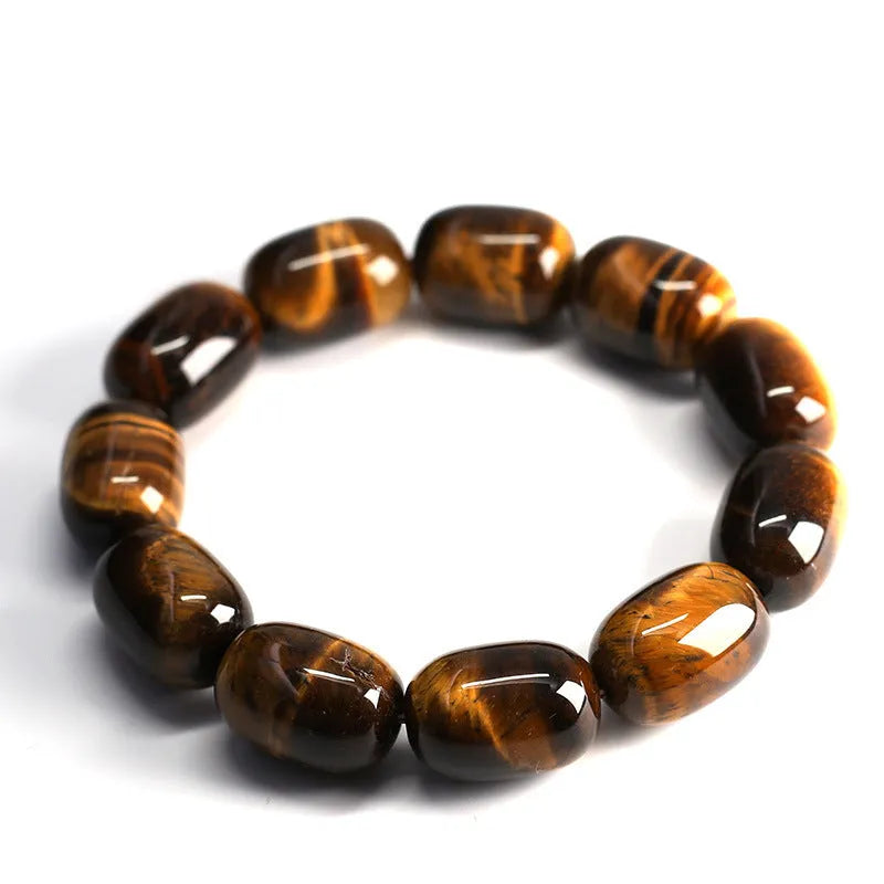 Close-up of a natural yellow Tiger Eye gemstone beaded bracelet with cat's eye effect on a wrist.