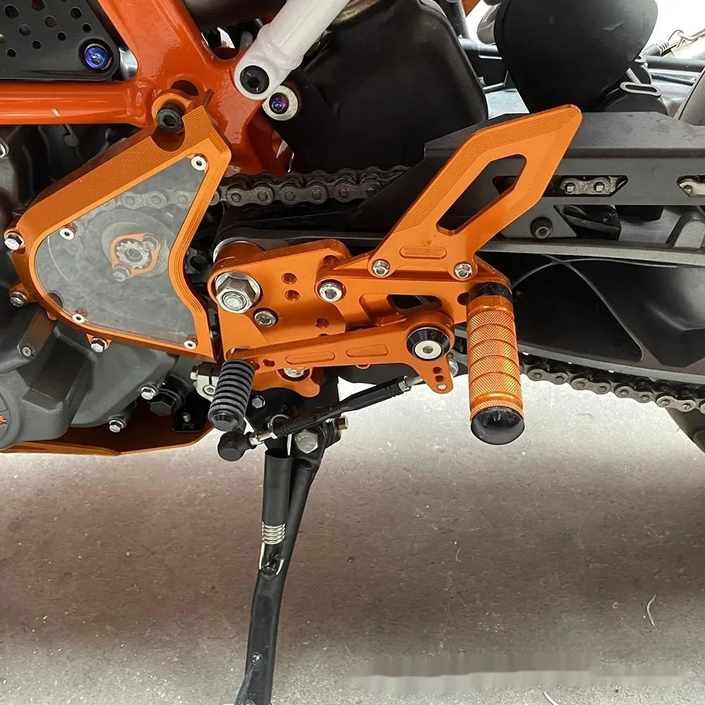 KTM Duke motorcycle rear shift pedal support assembly kit in black and orange.