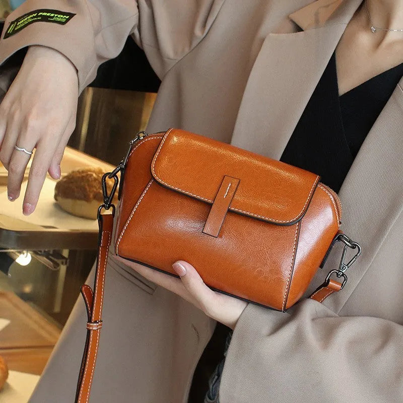 Women's brown oil wax cowhide shell messenger bag with cross-body strap and exterior sandwich pocket