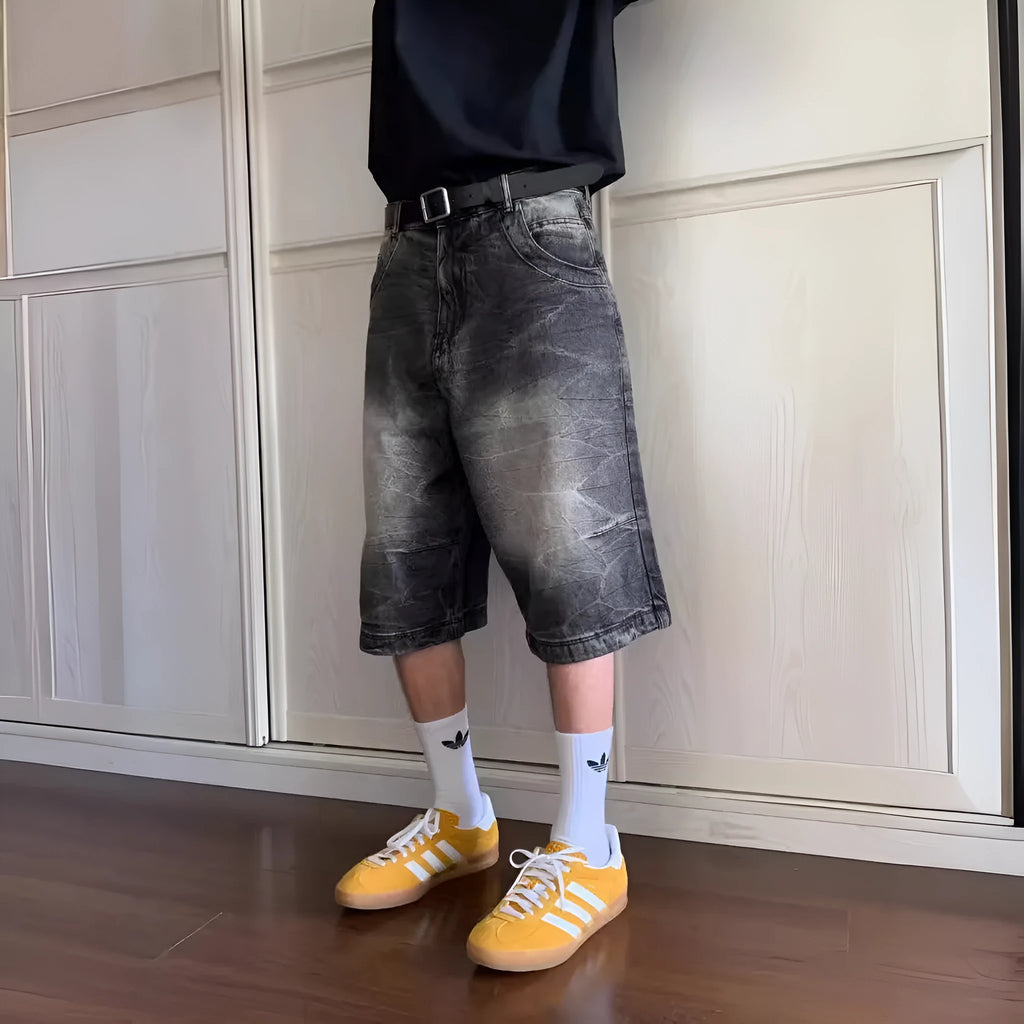 Man wearing loose light blue washed denim cowboy shorts with a straight-leg cut.