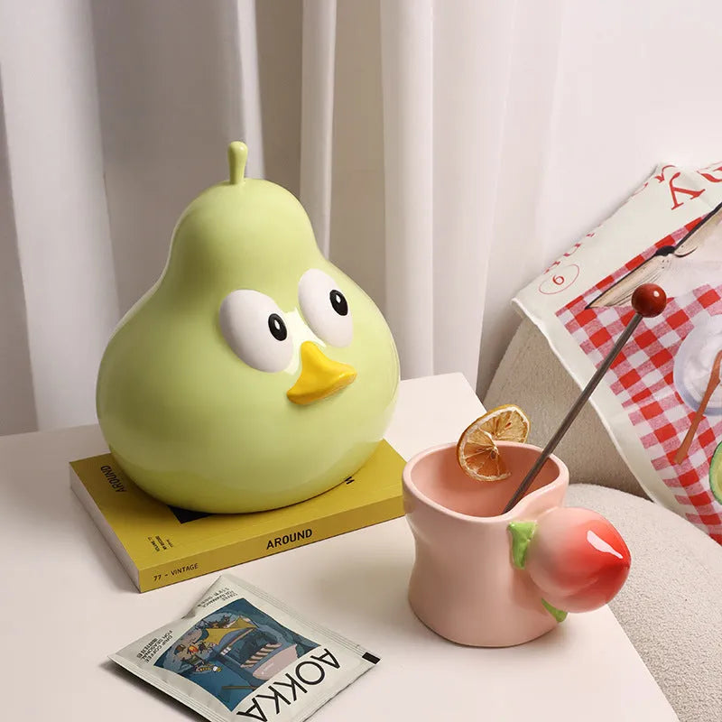 Green ceramic pear tissue box with animal style design on a wooden desktop
