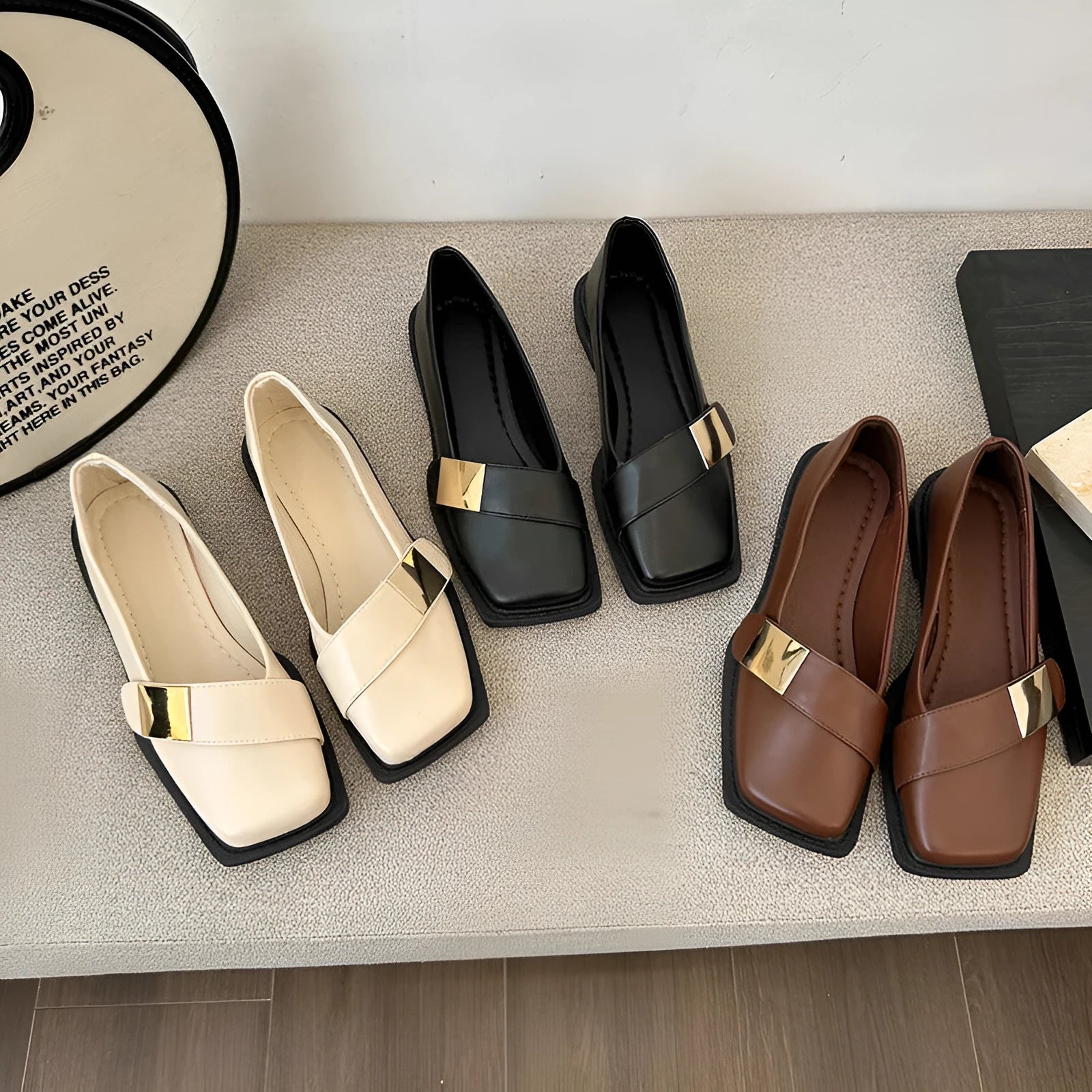 Women's beige square toe flat heel loafers with a silver metal buckle on the upper.