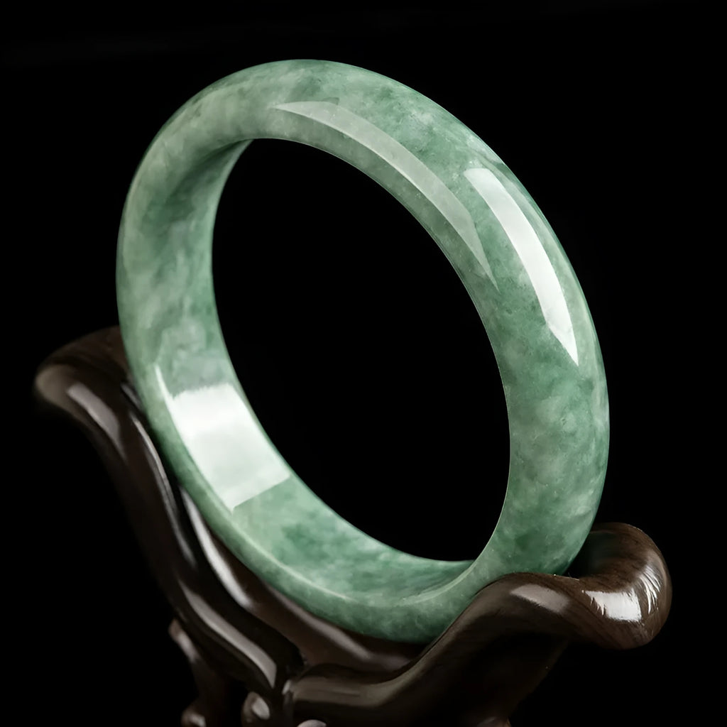 Women's simple bracelet with a natural green emerald bean gemstone on a wrist.