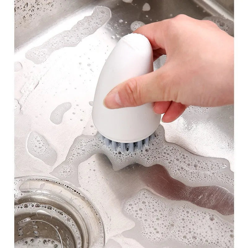 White and orange carrot-shaped kitchen cleaning brush with nylon bristles and a 15cm handle.