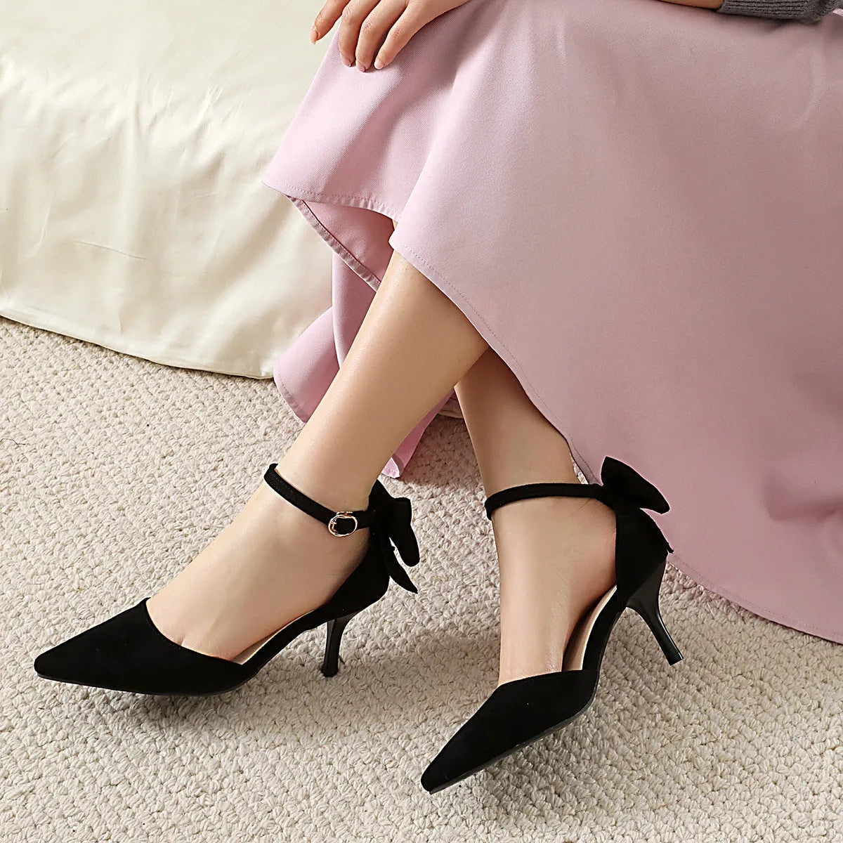 Women's black suede stiletto heels with pointed toe, bowknot detail and buckle fastening