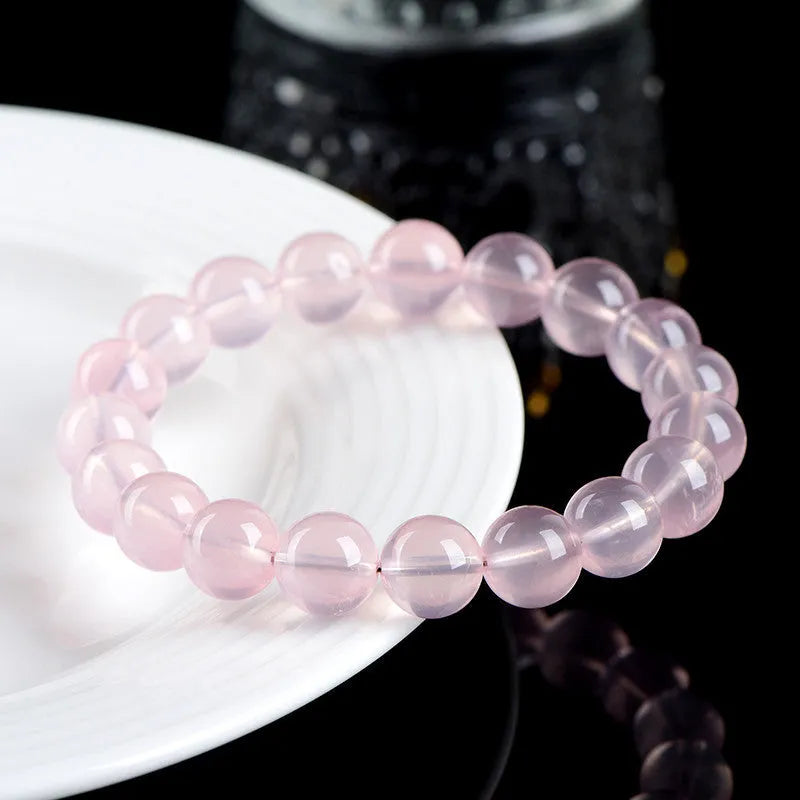 Natural crystal round beads bracelet with hand-polished finish in pink colour, showing seven size options from 6mm to 22mm diameter