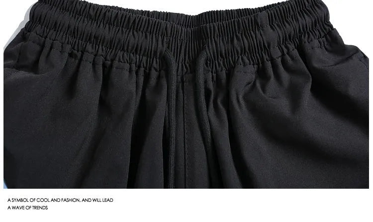 Loose-fit quick-drying sports shorts in black with elastic waistband and above-knee length