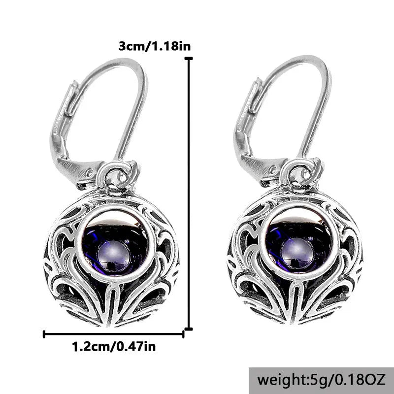 Silver geometric pendant earrings with vintage engraving and hollow design around blue gemstone