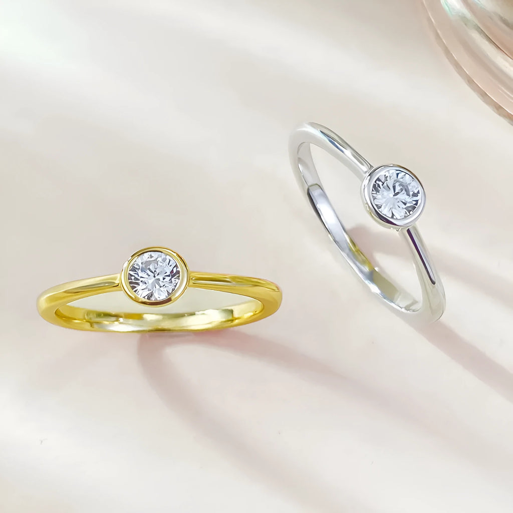 Minimalist silver crown ring with linear design details in R962 gold or platinum finish on a grey background.