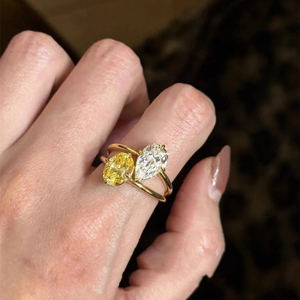 Geometric open copper ring with central water drop double Sheng stone accent on woman's finger