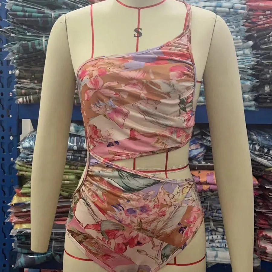 Women's rose gold patterned swimsuit on a hanger.
