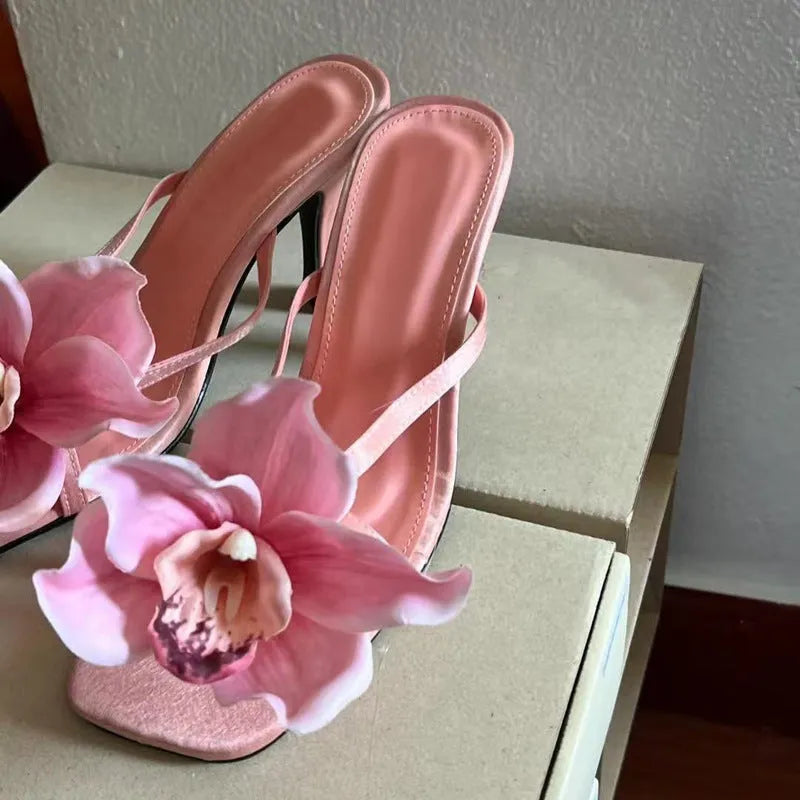 Pink women's high heel sandals with artificial white phalaenopsis flowers on the satin upper