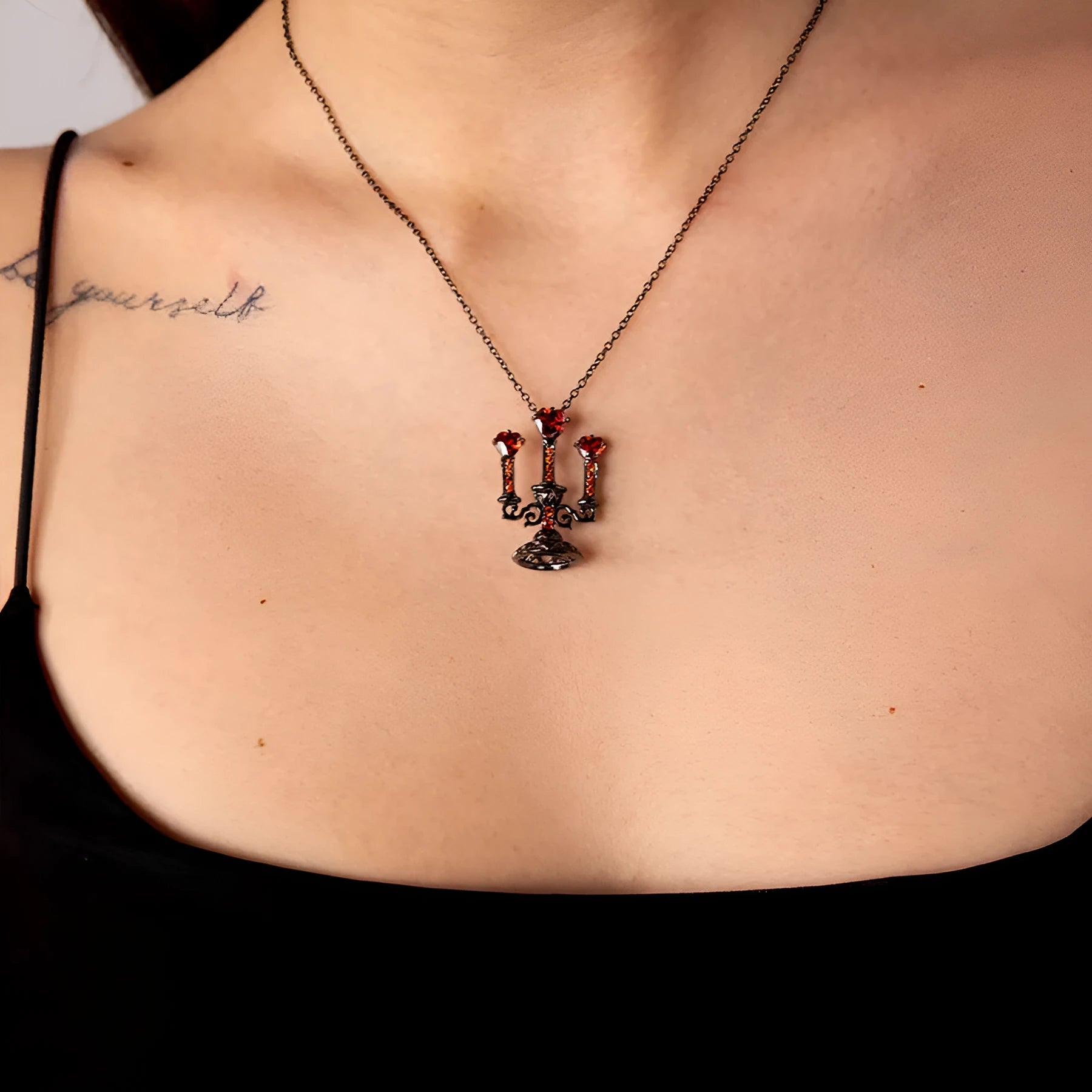 A women's gothic-style necklace with a hollow candlestick pendant on a cross chain, in a retro candlestick colour.