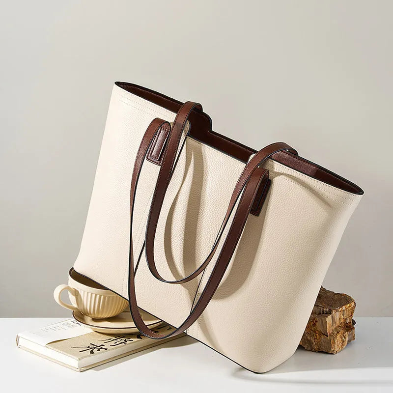 Women's black genuine cowhide leather commuter bag showing internal zipper change bag, mobile phone pocket, file compartment, and crossbody strap