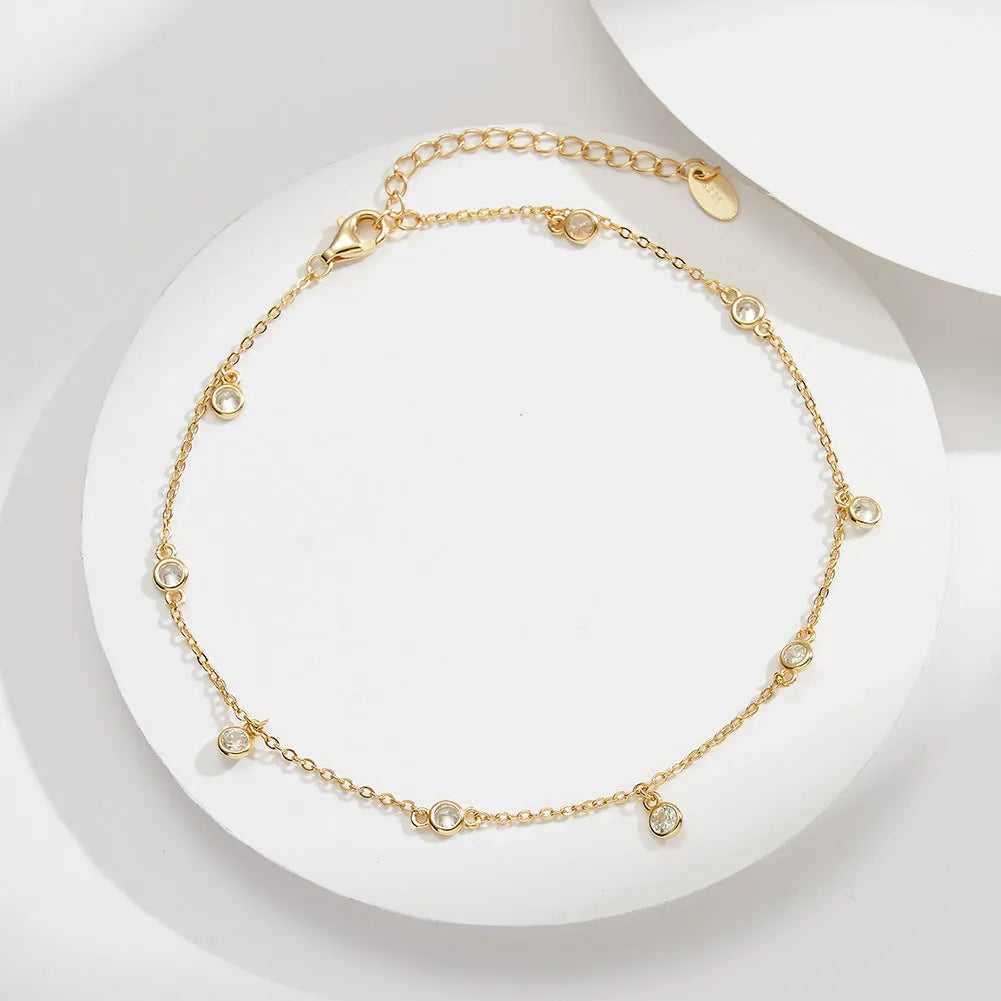 Women's sterling silver anklet with a geometric zirconium pendant on an ankle